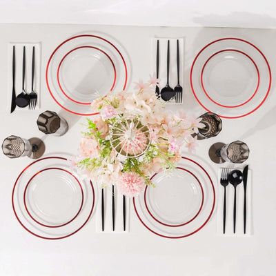 Elegant dining table setting with plates, cutlery, and floral centerpiece.