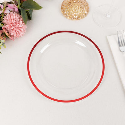 Clear plate with red rim on a neutral table setting.