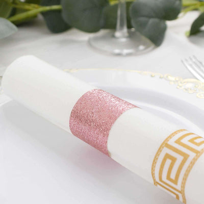 Elegant napkin ring with pink glitter and gold geometric design on a dining table.