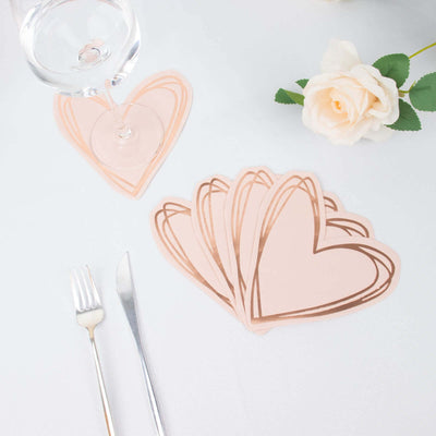 Heart-shaped coasters in rose gold and pastel pink on a table setting.