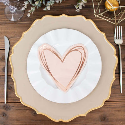 Rose gold heart-shaped plate on a decorative charger with silverware beside it.