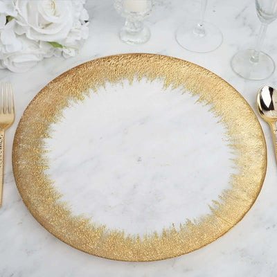 Gold-rimmed decorative plate on a marble table setting.