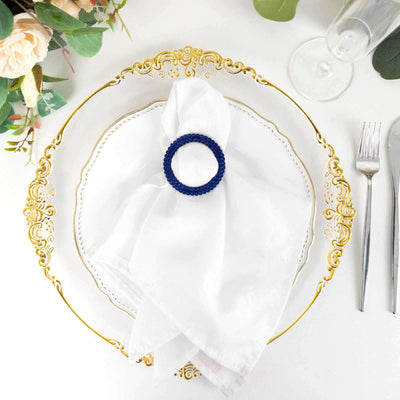 Elegant blue napkin ring on a white plate with gold trim.