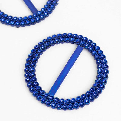 Blue beaded hair clips in a round shape on a plain background