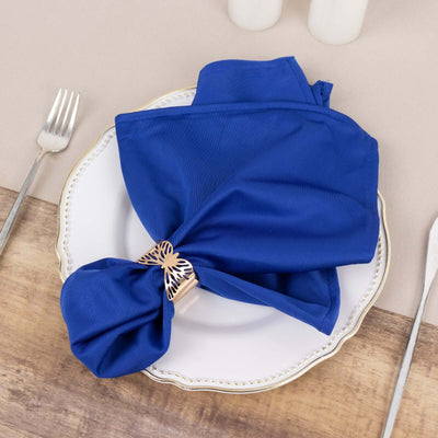 Blue napkin elegantly tied with a decorative ring on a white plate.