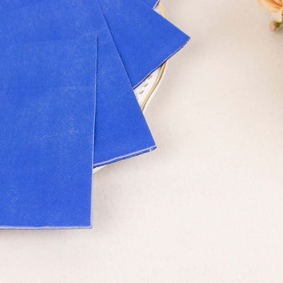 Blue paper sheets arranged on a plate with soft floral accents.