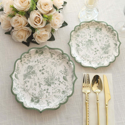 Elegant floral dinner plates with gold cutlery and a bouquet of roses on a table.