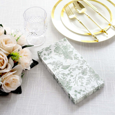 Floral patterned napkins on a table with elegant dinnerware and flowers.