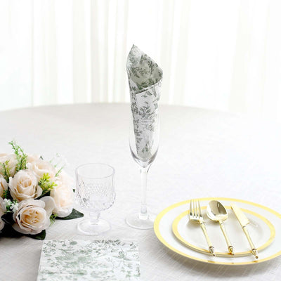 Elegant table setting with floral napkin, glass, and gold utensils.