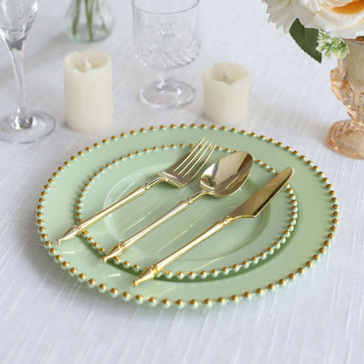 Elegant mint green plates with gold trim and cutlery on a table setting.