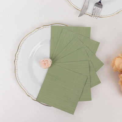 Green stationery set on a decorative plate with a small rose.