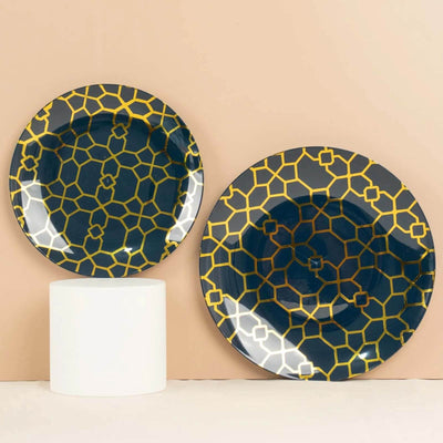 Decorative plates with geometric design in navy and gold against a beige background.