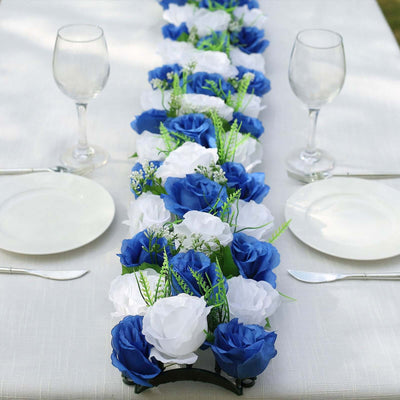 Blue and white floral table runner with greenery on a dining table.