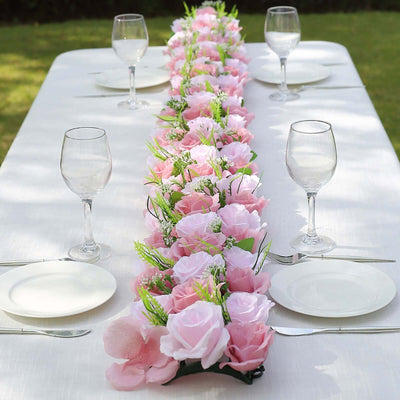 Elegant pink floral table runner on a dining table set for a meal.