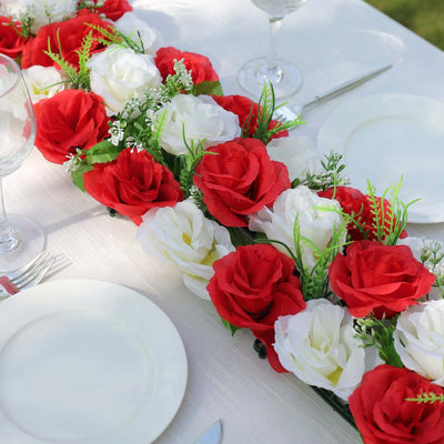 Decorative floral centerpiece featuring red and white roses on a table setting.