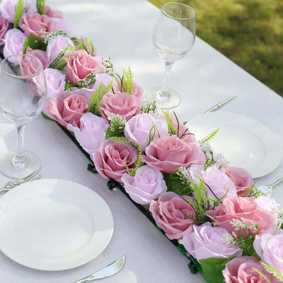 Pink and white floral centerpiece for table settings with glassware and plates.