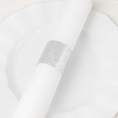 Silver glitter napkin ring on a white plate.