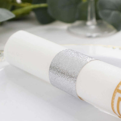 Silver glitter napkin ring on a white table setting.