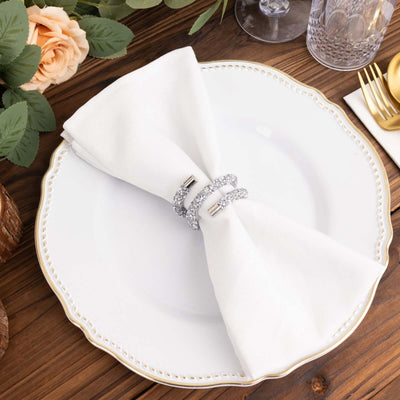 Elegant table setting with white napkin and sparkling napkin rings.