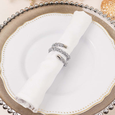 Elegant silver napkin ring with sparkling embellishments on a white napkin.