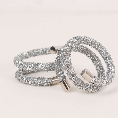 Silver glitter hair ties in a stacked arrangement.