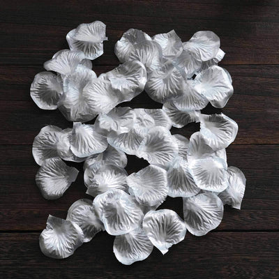 White flower petals scattered on a wooden surface.