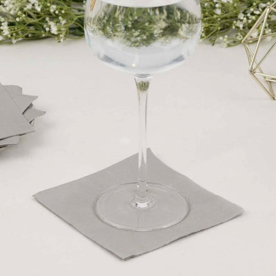 Glass of water on a gray napkin with decorative background elements.