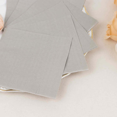 Gray fabric napkins arranged on a decorative plate.
