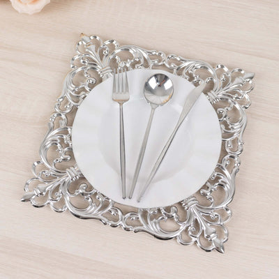 Elegant silver ornate charger plate with white dinner plate and cutlery.