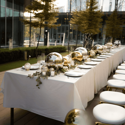 Elegant outdoor dining setup with glass decorations and greenery.