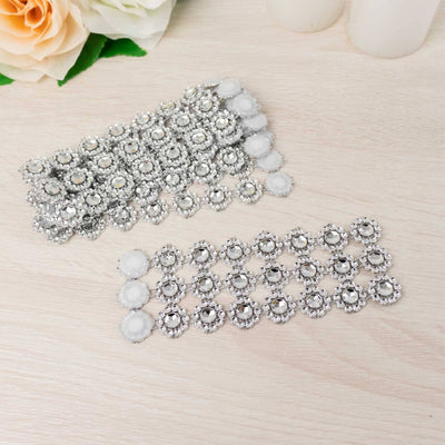 Silver rhinestone embellishments on a wooden surface.