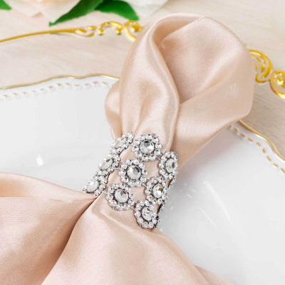 Elegant satin napkin with jeweled napkin ring on a decorative plate.