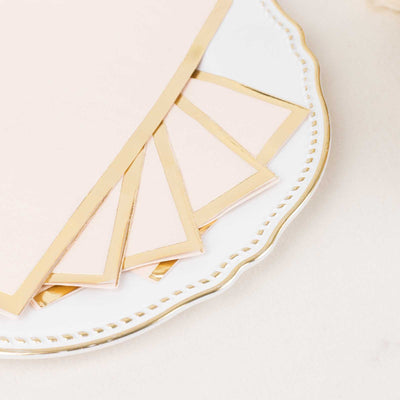 Gold-trimmed pink note cards on a decorative plate.