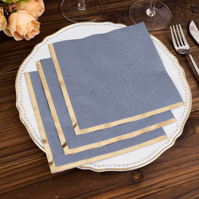 Elegant blue napkins with gold trim on a decorative white plate.
