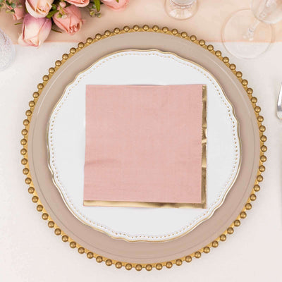 Elegant pink napkin on a decorative plate with gold accents.