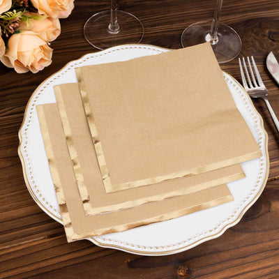 Gold-trimmed paper napkins arranged on an elegant plate with cutlery.