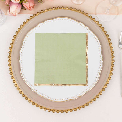 Elegant green napkin with gold trim on a decorative plate