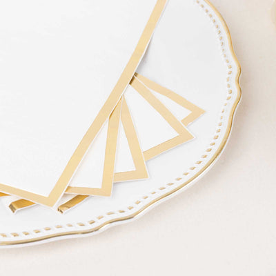 Elegant gold-trimmed note cards on a decorative white plate.