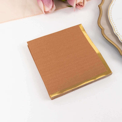 Brown notepad with gold foil edges on a white surface.