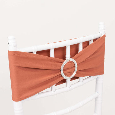 Rust-colored chair sash with rhinestone buckle on a white chair