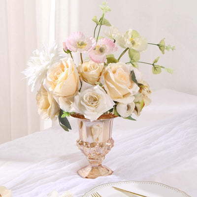 Elegant floral arrangement in a decorative vase with soft roses and greenery.