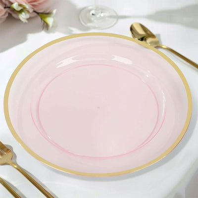 Pink plate with gold rim on a table setting.