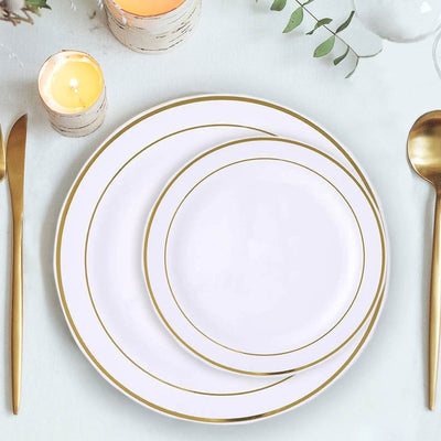 Elegant white plates with gold rims, arranged on a table setting.