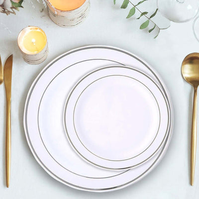 Elegant white dinner plates with gold trim arranged on a table setting.