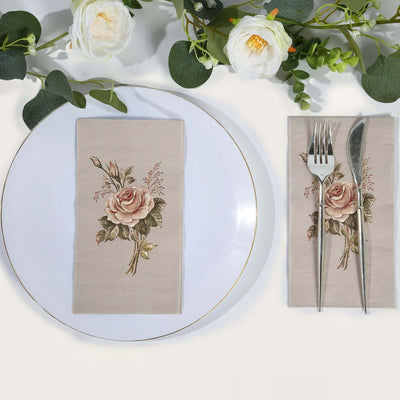 Rose-printed napkin on a plate with cutlery, surrounded by greenery.