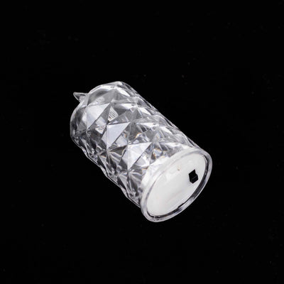 Crystal candle holder with diamond pattern on a black background.