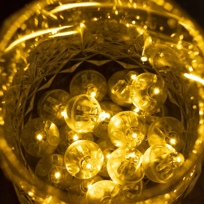 Warm white LED string lights inside a decorative glass bowl.