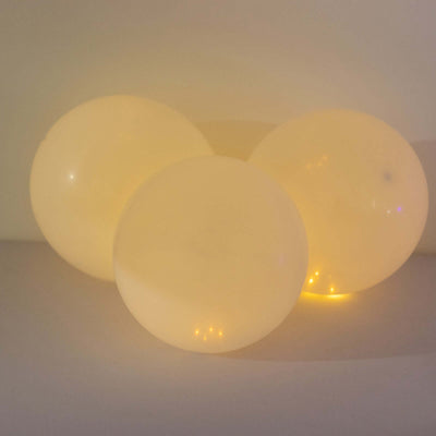Glowing soft yellow balloons on a plain background