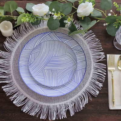 Decorative plates on a woven placemat with greenery and candles.