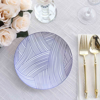 Decorative plate with a modern line pattern on a dining table setting.
